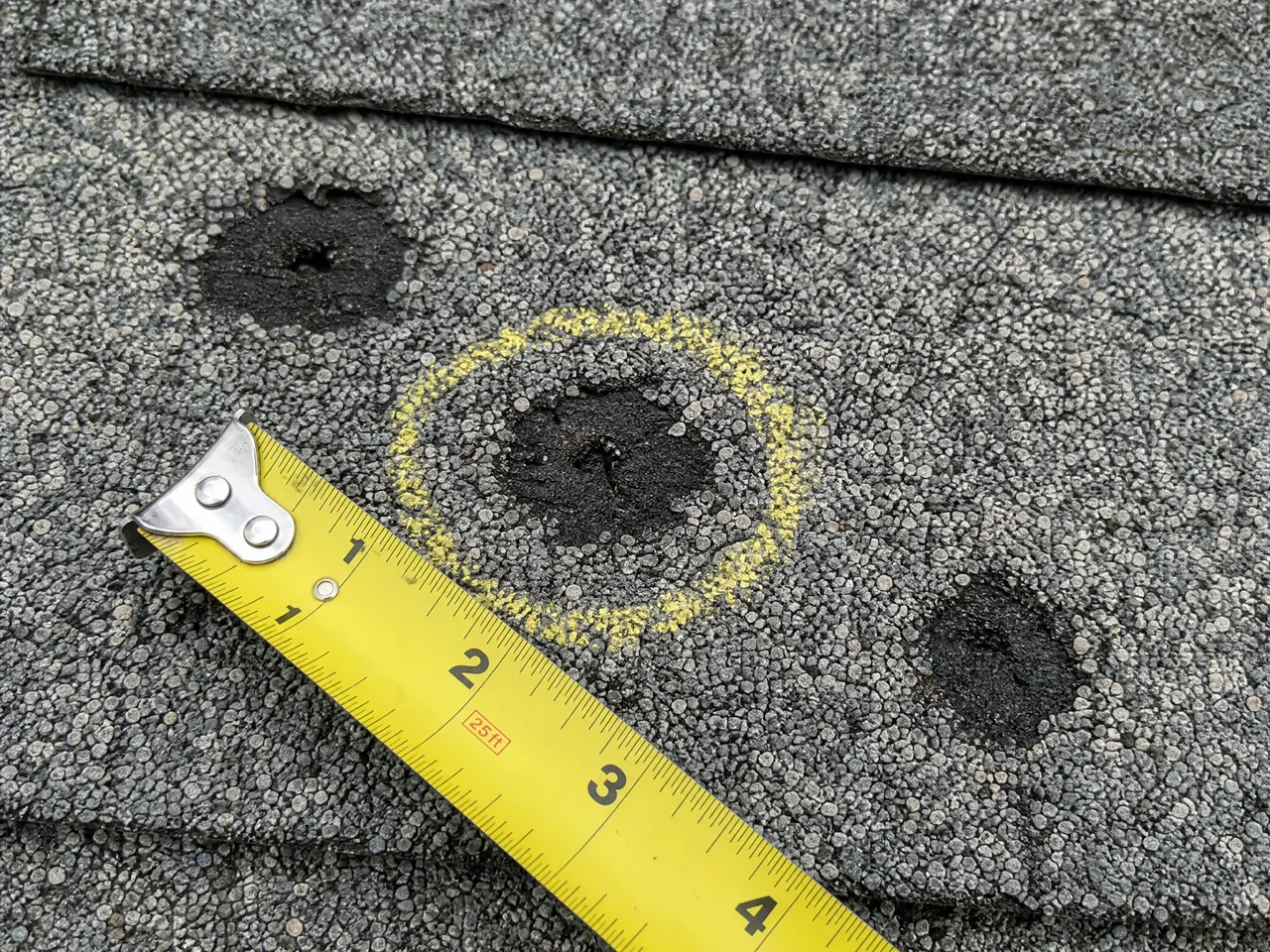 Close-up of hail bruising on an asphalt shingle roof in Aurora Illinois