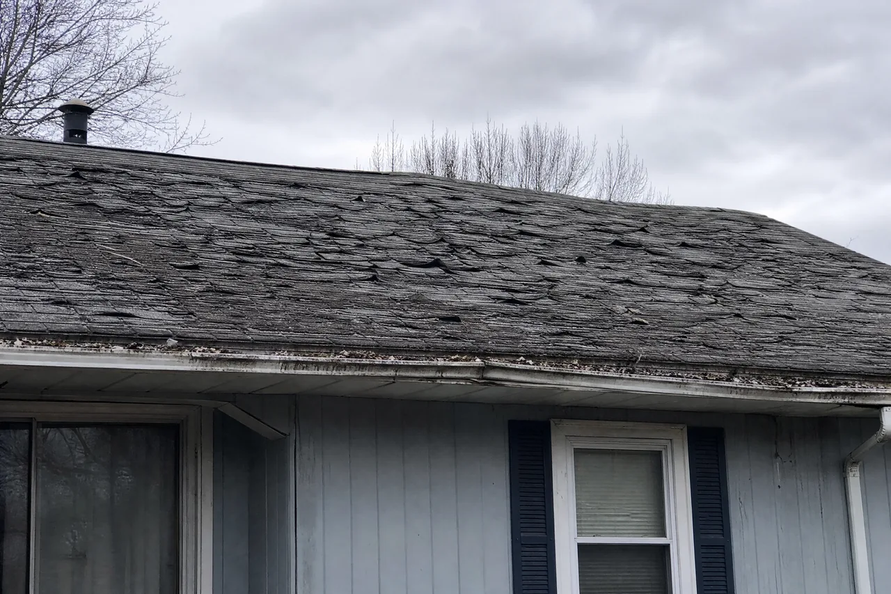 Aurora IL roof before replacement with curling shingles and a sagging ridge
