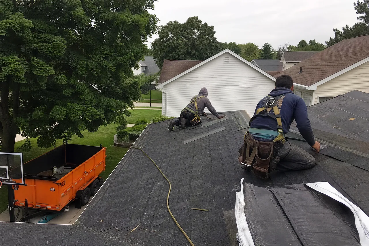 Aurora IL roofing company crew installing architectural shingles on a two-storey home