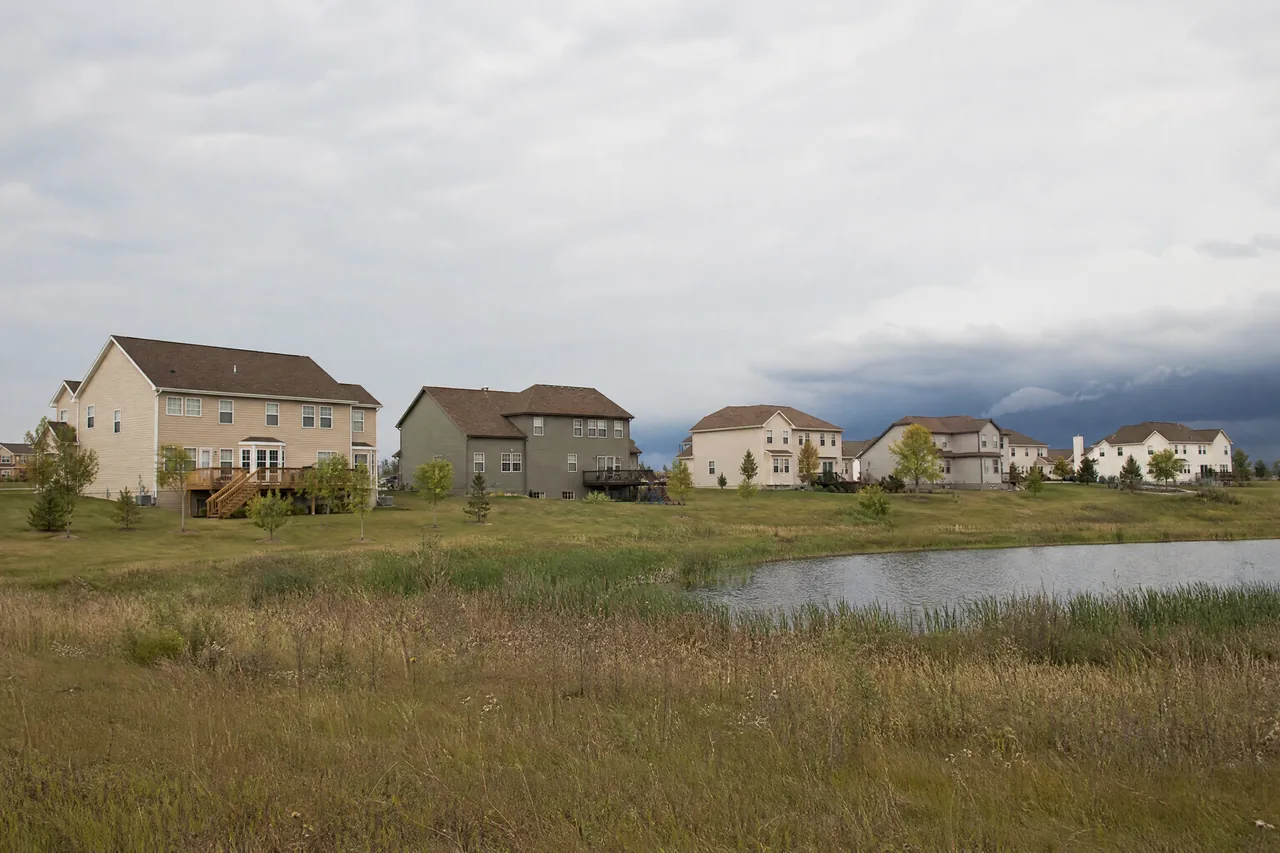 Open subdivision roofs under building storm clouds in Plainfield IL