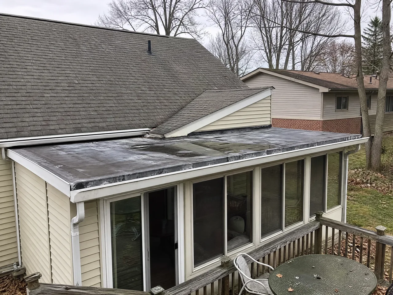 Low-slope sunroom addition roof meeting the main roof on a Warrenville IL home